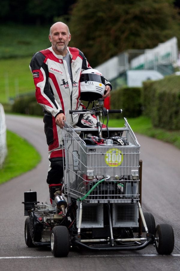 Matt Mckeown 55 stand's next to his hill climb vehicle a converted shopping trolley. Shelsley Walsh Hill Climb, Shelsley Walsh, Worcestershire. September 04, 2016. This is the bizarre moment a petrol head competed in a motorcycle road race - in a jet-powered SHOPPING TROLLEY. See NTI story NTITROLLEY. Madcap Matt McKeown, 55, of Plymouth, Devon, build his wacky racer - which has a top speed of 80mph - from an abandoned cart he found in a ditch. He bolted on brakes, go-kart wheels and a 150 horsepower engine from a Chinook helicopter before taking it for time trials. Matt first set a record of 45.5mph then made several tweaks and broke his own record by reaching 71.4mph at Elvington Airfield in North Yorks. On Sunday (4/9) Matt wowed the crowds when he competed in the Shelsley Walsh Hill climb in Worcestershire. Despite crawling up the 1,000 yard course - which hits a steep 1:7 incline at its peak - Matt wasn't last to finish and managed to beat a number of other conventional bikes.