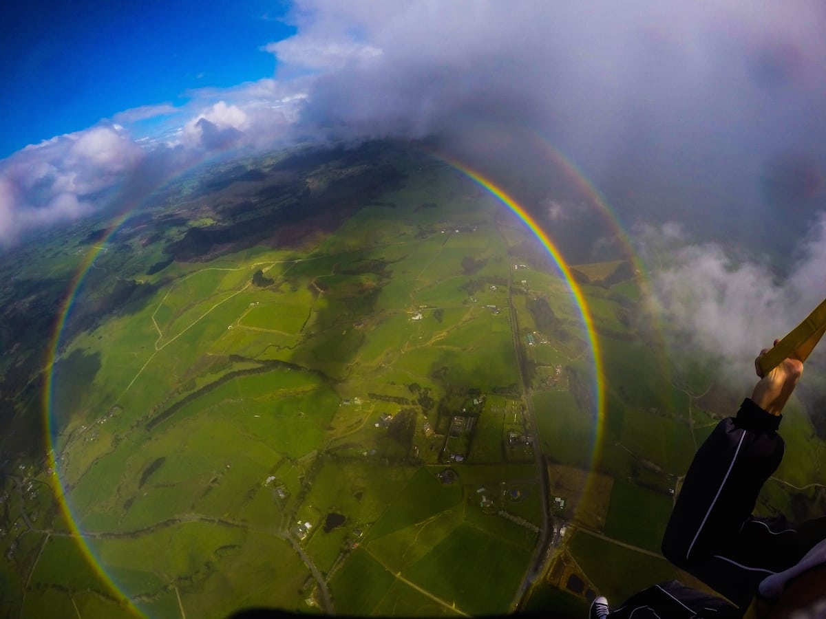 Anthony Killeen gets the thrill of his life as he skydives over a 360 degree rainbow. See SWNS story SWRAINBOW; The British expat was on his first skydive with an instructor over New Zealand's Bay of Islands when he spotted the perfect circles of colour. Killeen said the rainbow kept its form until it was time to descend and land. "All the instructors said they hadn't seen that before either - some had seen it from the plane, but never whilst diving."