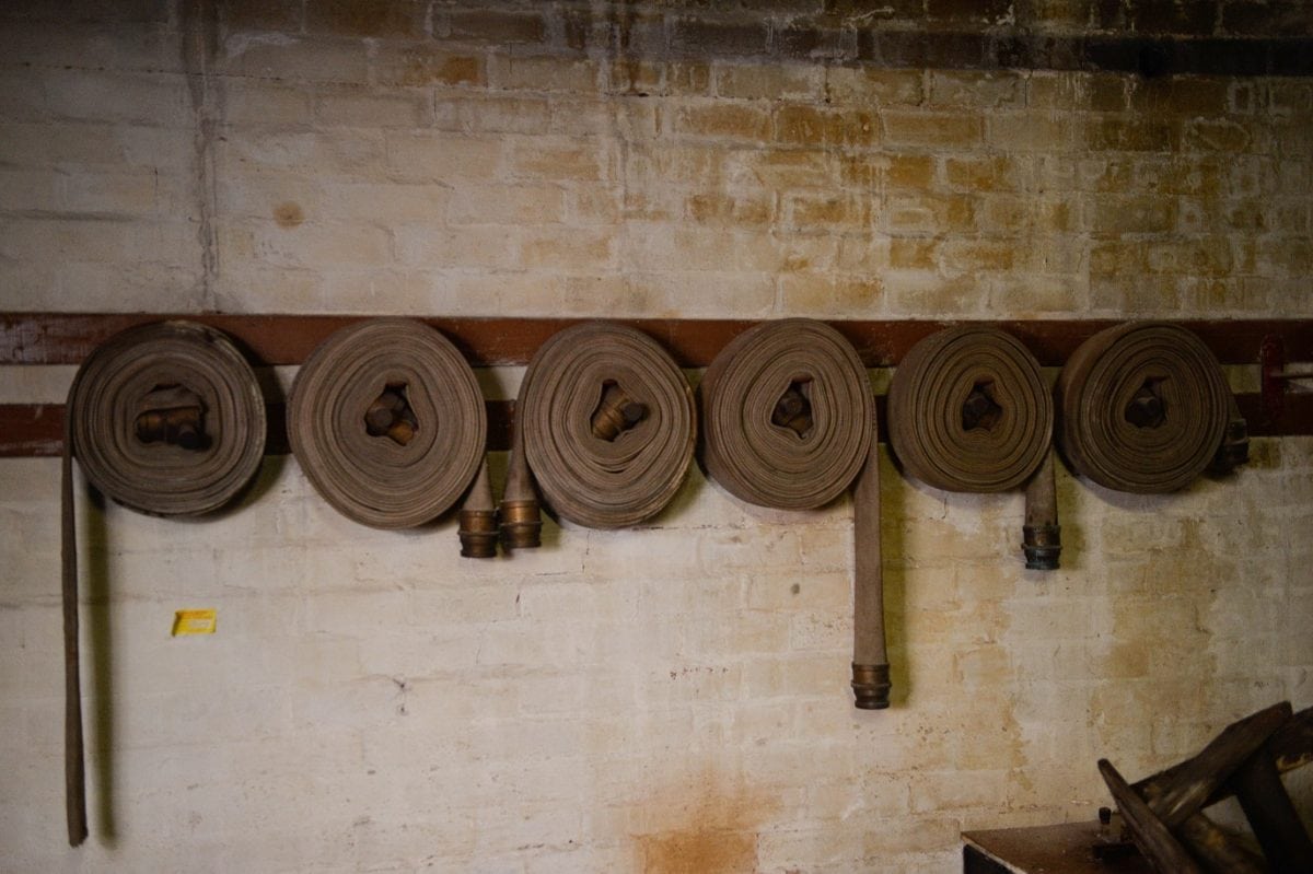Fabric hoses left coiled on the walls ready to be used. These remarkable pictures show a fire station which was left untouched for more than 60 years before it was discovered in the cellar of an old Co Op factory. See NTI story NTIFIRE. The secret fire station is complete with 1920s firefighting equipment, pumps, uniforms and coiled hoses. A half-drunk bottle of lemonade and exercise programmes were also found in the cellar of the former Co Op factory in Dudley, West Mids. Staff at shopfitting company The Allan Nuttall Partnership, which is now based in the building, heard rumours of a hidden fire station but dismissed it as an "urban myth". But when marketing manager Anna Bramford dug out some keys she was astonished to find fire regalia and pumps dating back to the 1920s.