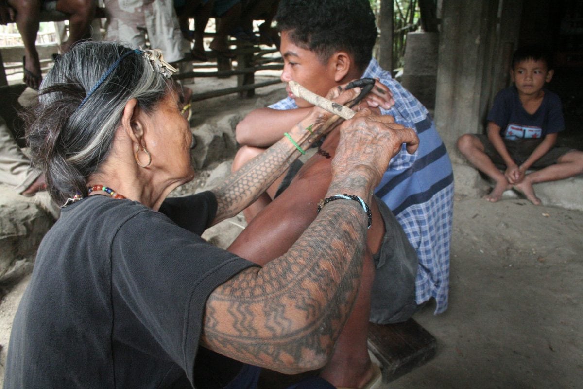 Meet the world's oldest tattooist whose tribal inkings are 20 TIMES more painful than normal body art. See SWNS story SWTATT; Filipino spinster Whang-od, 97, dedicated her life to tattooing villagers since she learned the ancient practice aged just ten. She uses charcoal and water to make the ink, which is then hammered inside the skin using a THORN from a tree. Hundreds of 'tattoo tourists' a year now trek to her remote mountain village in Kalinga province, some ten hours from the Philippines capital Manilla, for one of her ancient designs.