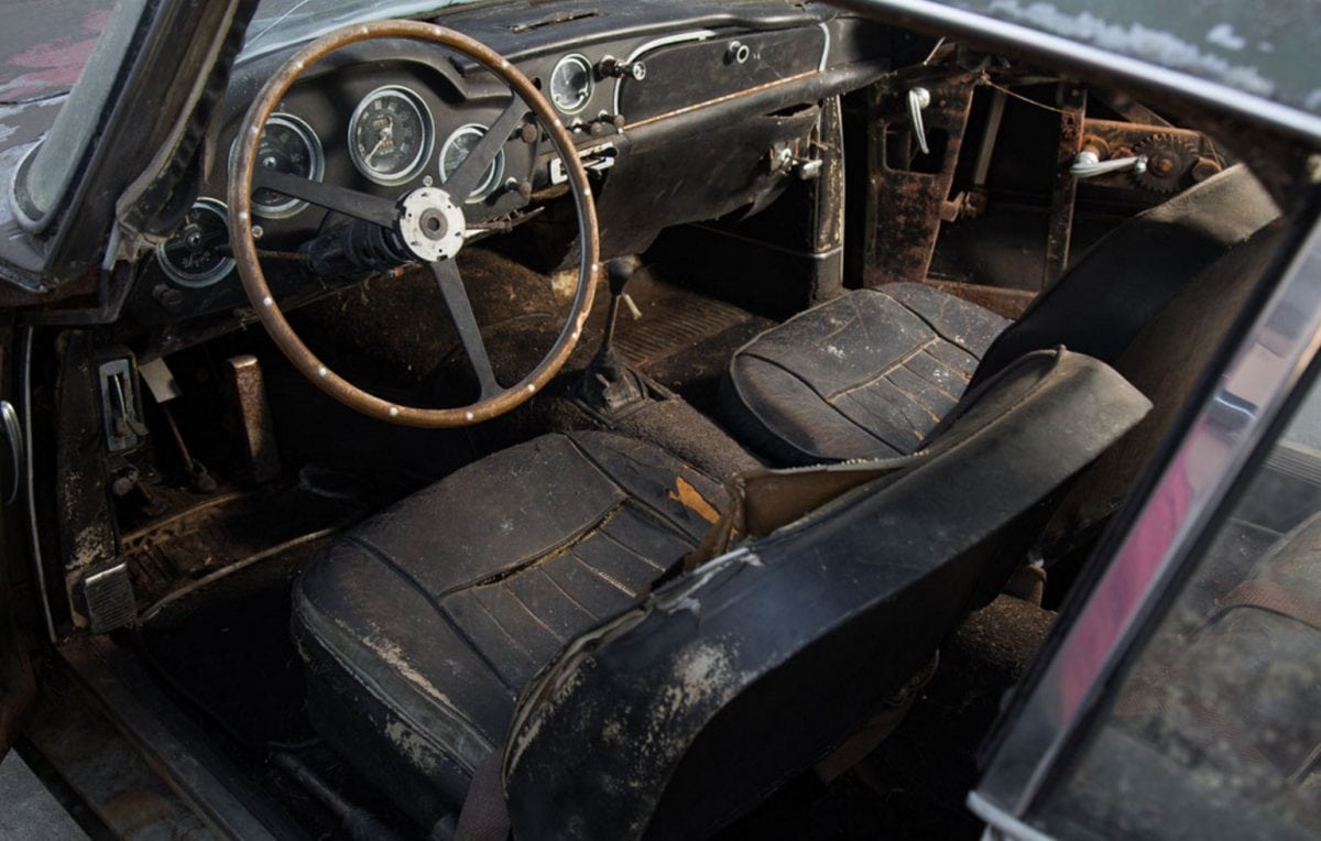 A classic Aston Martin is expected to sell for more than £350,000 despite being a wreck which has languished in a wood for more than 40 YEARS. See SWNS story SWASTON; The Aston Martin DB4 was the first production car capable of doing 0-100-0mph in less than 30 seconds when it was launched in 1958. It was built to compete with sports cars from Ferrari and Maserati - but this particular model hasn’t moved in almost half-a-century. The car was manufactured in the UK in 1960 and then shipped across to the USA, where it was registered the following year. At some stage in the early 1970s it was parked outdoors at the owner's home in New Hampshire, Massachusetts, USA, where it remained until recently. Over the past five decades, the car’s condition has deteriorated after it was surrounded by trees and buried halfway up to its now rusty wheels by leaves.