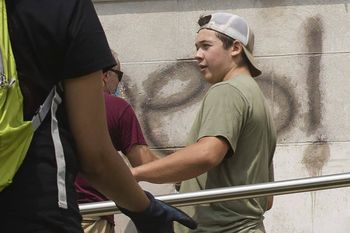 Kyle Rittenhouse helps clean the exterior of Reuther Central High School in Kenosha, Wis., on Tuesday, Aug. 25, 2020. Rittenhouse, 17, was arrested Wednesday, Aug. 26, after two people were shot to death during protests in Kenosha over the police shooting of Jacob Blake. (Pat Nabong/Chicago Sun-Times via AP)