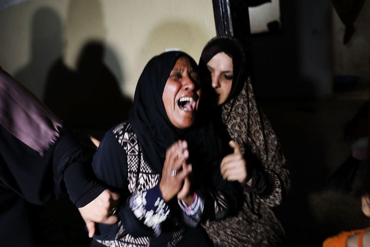Women grieve as they body of eight-month-old Leila Anwar Ghandoor, who died in the hospital on Tuesday morning from tear gas inhalation, is prepared for burial, 2018 in Gaza City / Getty Images