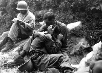 A grief stricken American infantryman whose buddy has been killed in action is comforted by another soldier. In the background a corpsman methodically fills out casualty tags, Haktong-ni area, Korea.  August 28, 1950.  Sfc. Al Chang. (Army)
NARA FILE #  080-SC-347803
WAR & CONFLICT BOOK #:  1459
