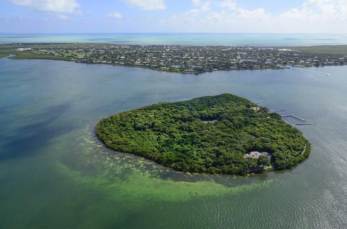 This 26 acre tree-covered private island with marina and beach has been put on the market for £75 MILLION. See SWNS story SWISLAND; Pumpkin Key is an "extraordinary" retreat which boasts a three-bedroom main home, two caretaker's cottages and a dock master's apartment. It also has a 20-slip marina which is large enough to accommodate a megayacht. The island, which is a ten-minute helicopter ride from Miami's famous South Beach, has panoramic views of Card Sound Bay and spectacular sunsets.