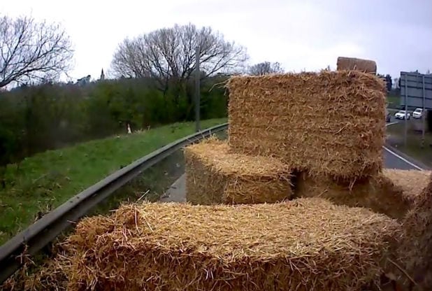 Lorry Carrying Bales Of Hay Is Overturned As It Takes Corner At High Speed