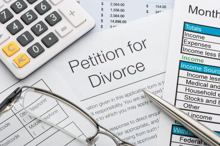 Close up of a petition for divorce with pen and calculator