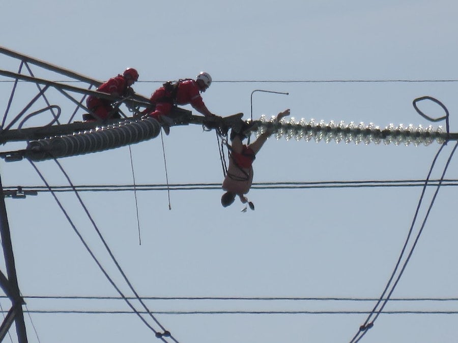  Man dramatically rescued after being spotted “dangling” 60 feet from the ground on an electricity pylon