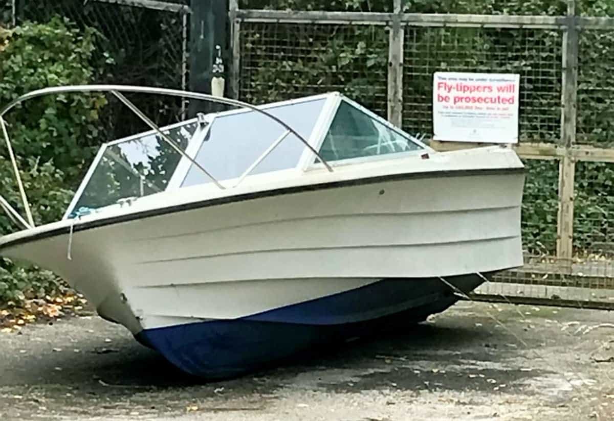 ULTIMATE FLY-TIP AS A BOAT IS ABANDONED IN FRONT OF A NO FLY TIPPING SIGN