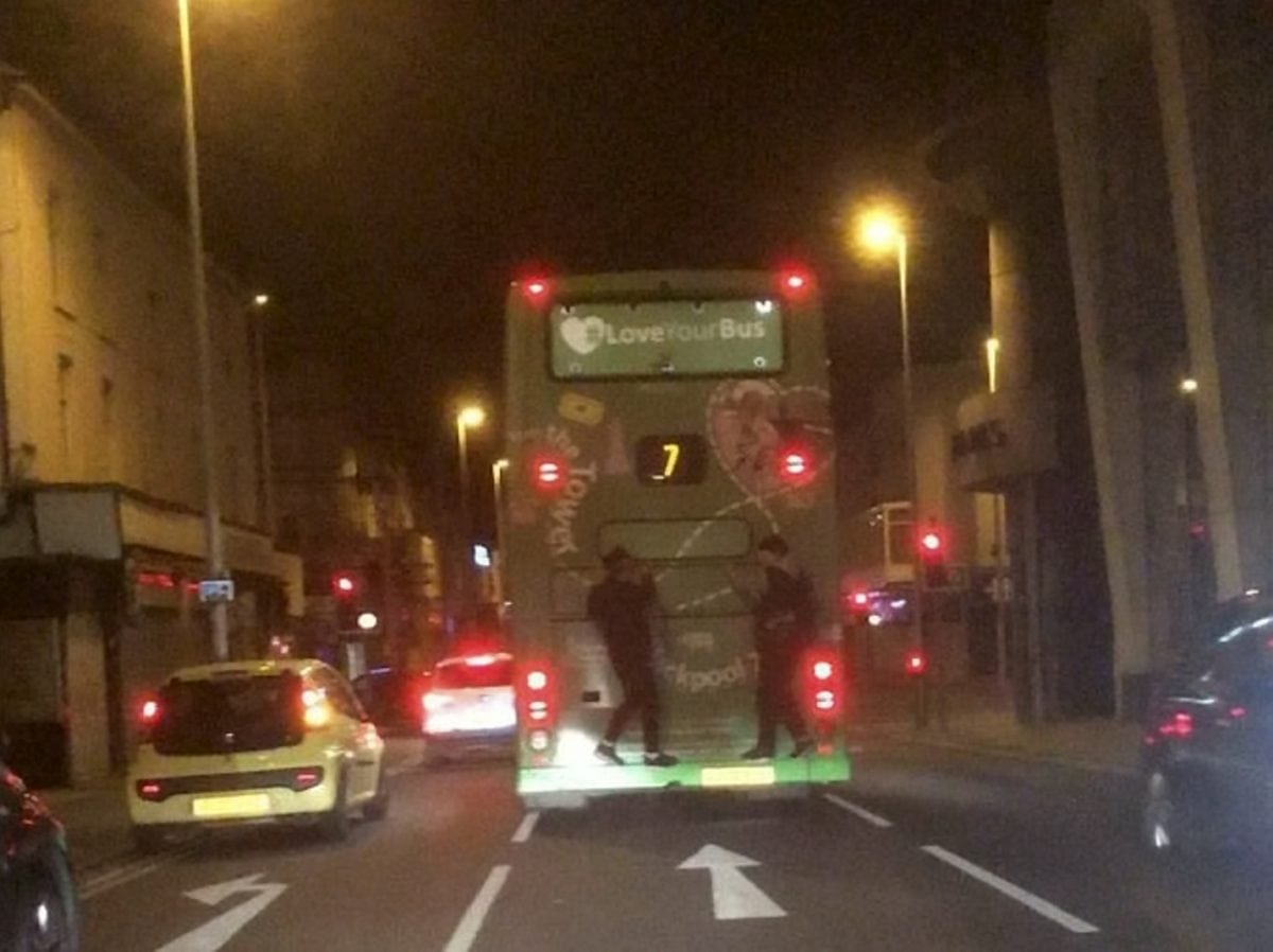 Two “faredevils” avoid paying by clinging onto the back of a bus