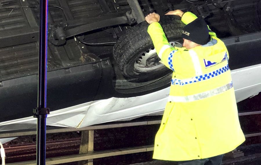 Hero police officer clung on to a van hanging precariously over the edge of a motorway bridge to stop it from toppling below — with his BARE HANDS