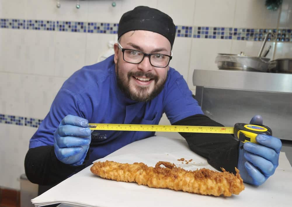 Chippy owner has created a giant foot-long ‘pig in a blanket’ as a Christmas treat for customers — which is over 1000 CALORIES