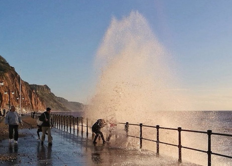 Mum pictured playing chicken with young children in 30ft waves