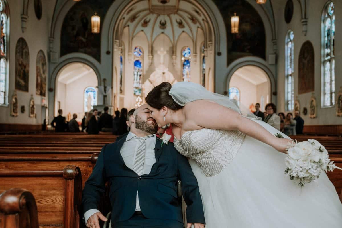 Touching moment wheelchair-bound groom overcome with emotion as bride walks down the aisle