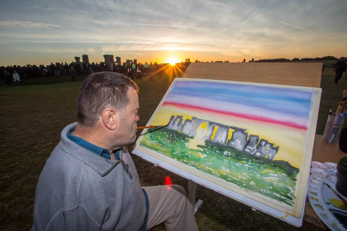Mouth & foot artist captures sunrise in colourful painting at Stonehenge’s summer solstice