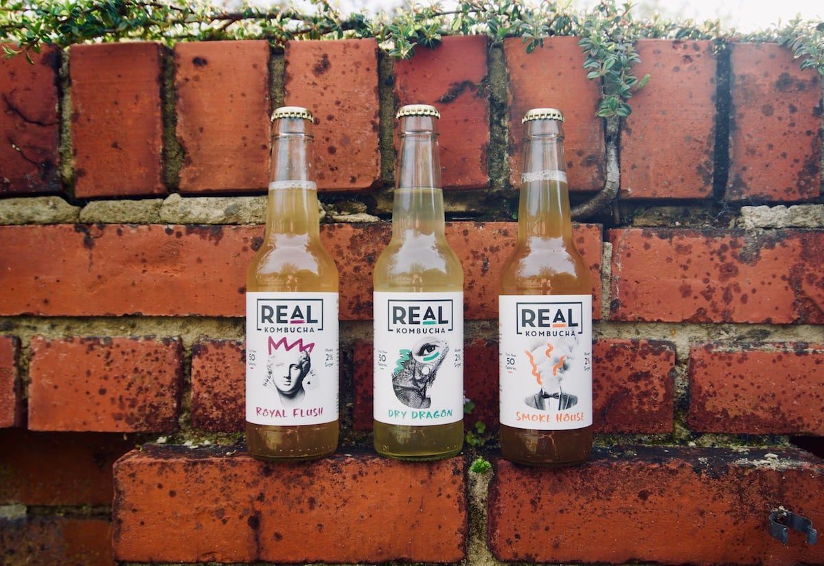 Real Kombucha bottles brick wall