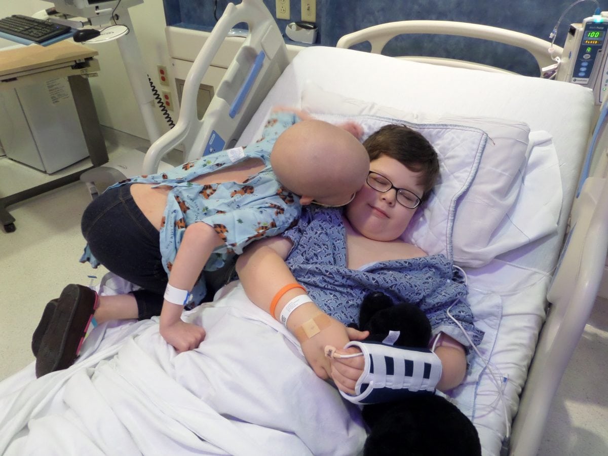 Photo of girl giving big brother thank you kiss after he saved life with bone marrow transplant
