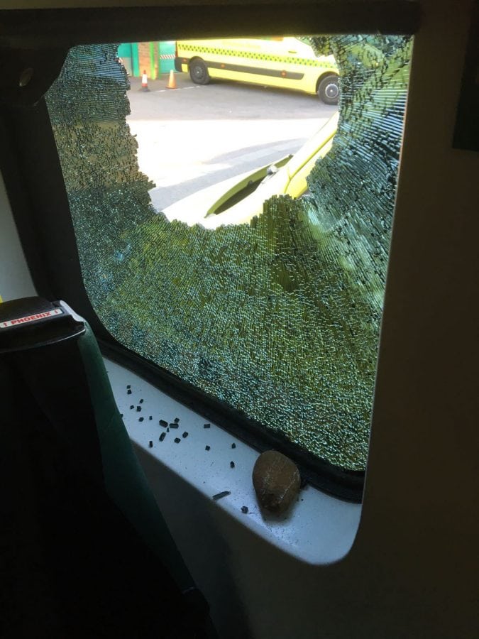 Rock thrown through ambulance window narrowly misses patient inside