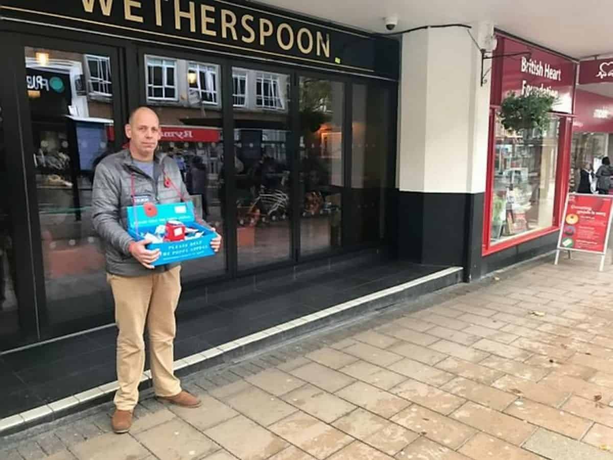 Poppy seller .Pete West, 47, who was forced to stand in the rain - after a Wetherspoons pub manager told him he couldn't use the pub's concrete canopy.See SWNS story SWPLpoppy.Pub chain Wetherspoons has apologised after staff forced a poppy seller who was seeking shelter outside one of their pubs - to stand out in the rain.Pete West, 47, was selling the Royal British Legion's decorative poppies to passers-by as the heavens opened.To stay dry, Pete stood under a concrete canopy which forms part of The Chevalier pub in Exeter, Devon.But the manager of the pub came out and told Pete he wouldn't be able to stand there as they didn't have a license. (SWNS)