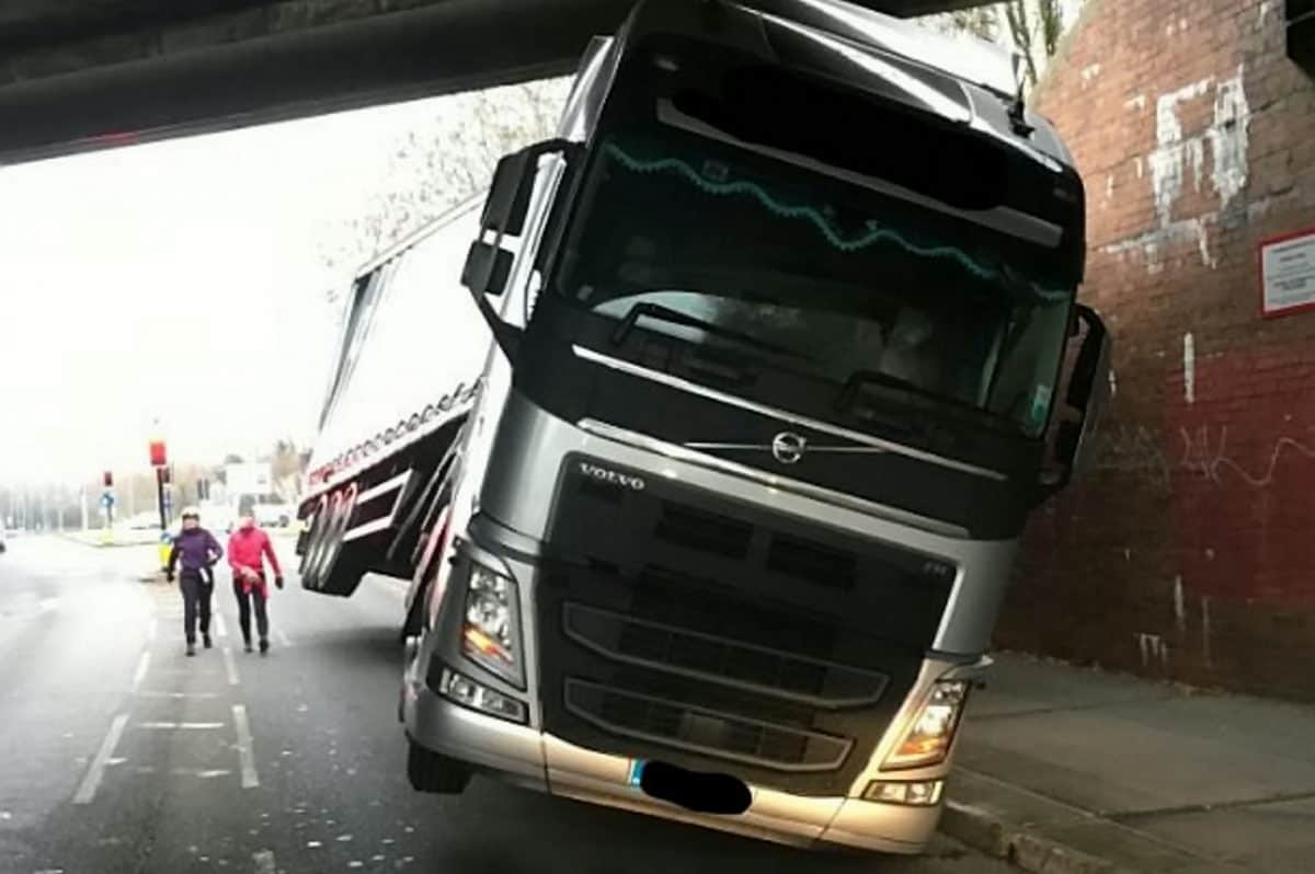 Bizarre photos show lorry tilted on two wheels trapped underneath a bridge