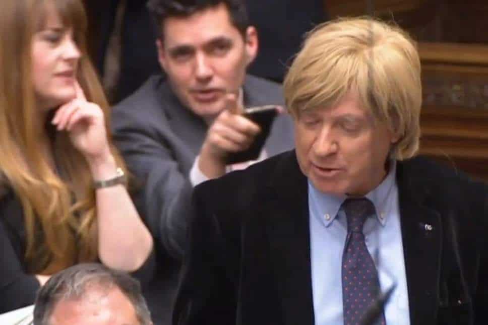 Conservative MP making fun of colleague behind his back during PMQs – because of his WIG