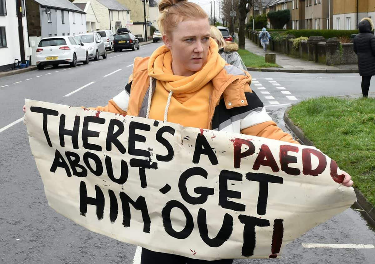 Protesters wave signs including ‘Watch out, there’s a paedo about’ outside home of convicted paedophile
