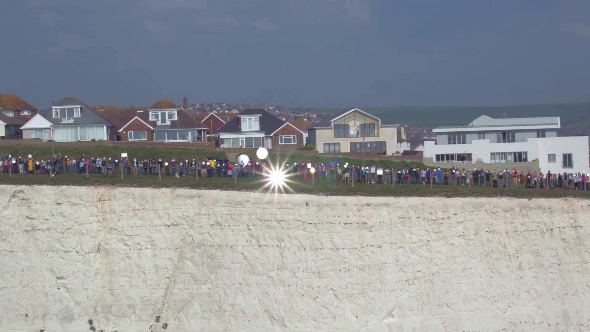 Video – 400 people gathered with mirrors on south coast to flash SOS signal to Europe