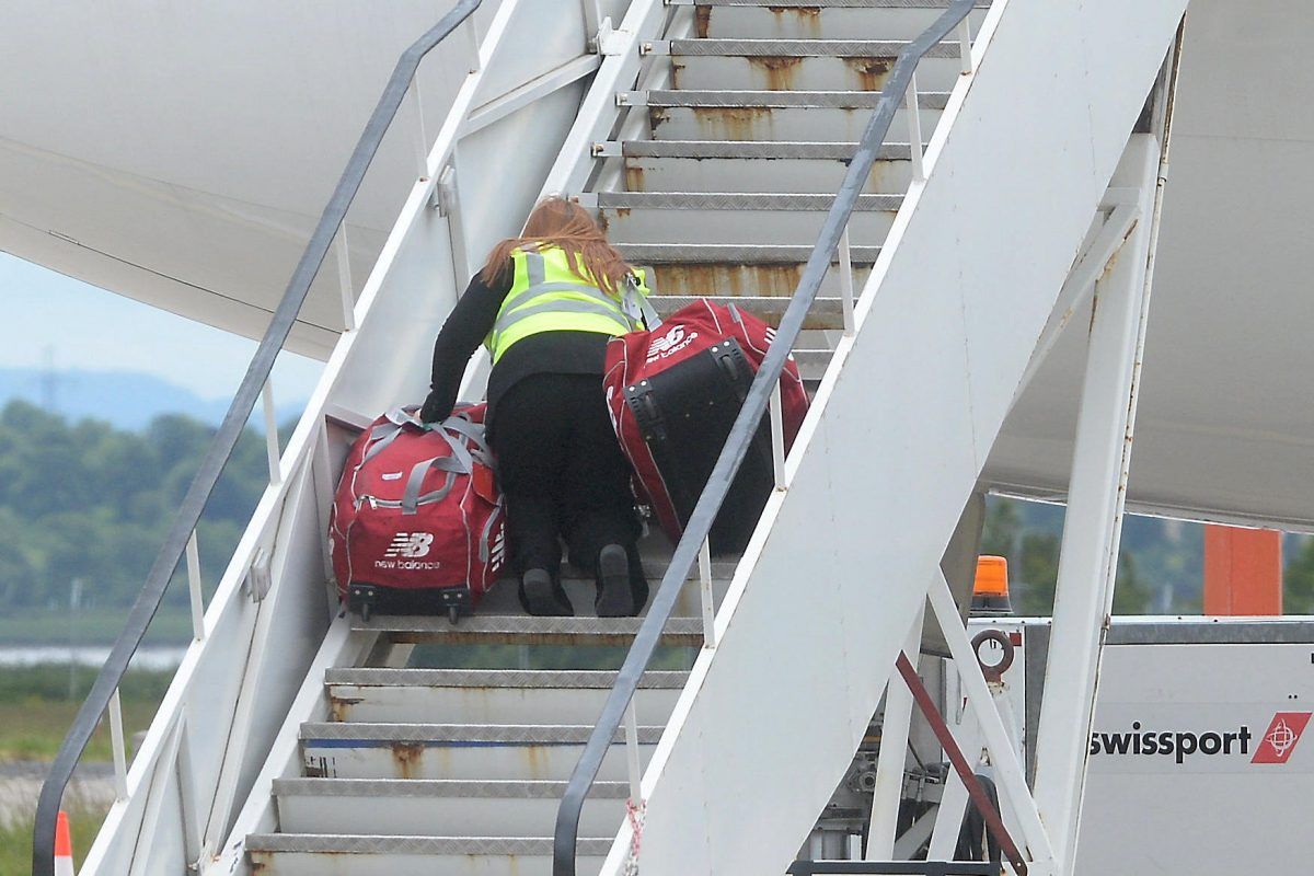 Female baggage handler struggling to carry Liverpool players’ kitbags onto plane – they wander up empty handed