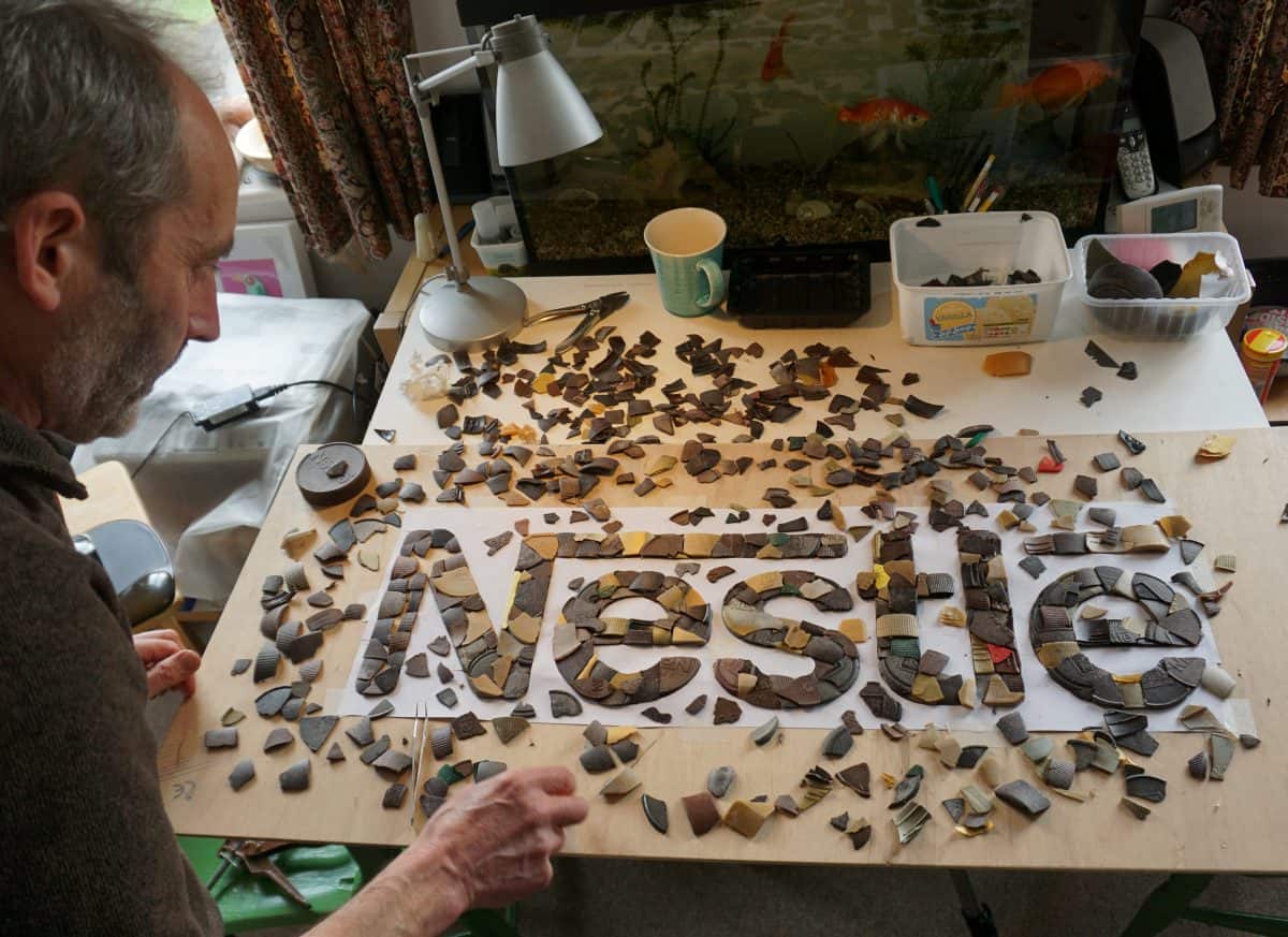 Artist creates Nestle’s logo with plastic waste from its products washed up on British beaches