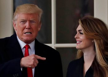 FILE PHOTO: U.S. President Donald Trump reacts as he stands next to former White House Communications Director Hope Hicks outside of the Oval Office as he departs the White House for a trip to Cleveland, Ohio, in Washington D.C., U.S., March 29, 2018. REUTERS/Carlos Barria/File Photo