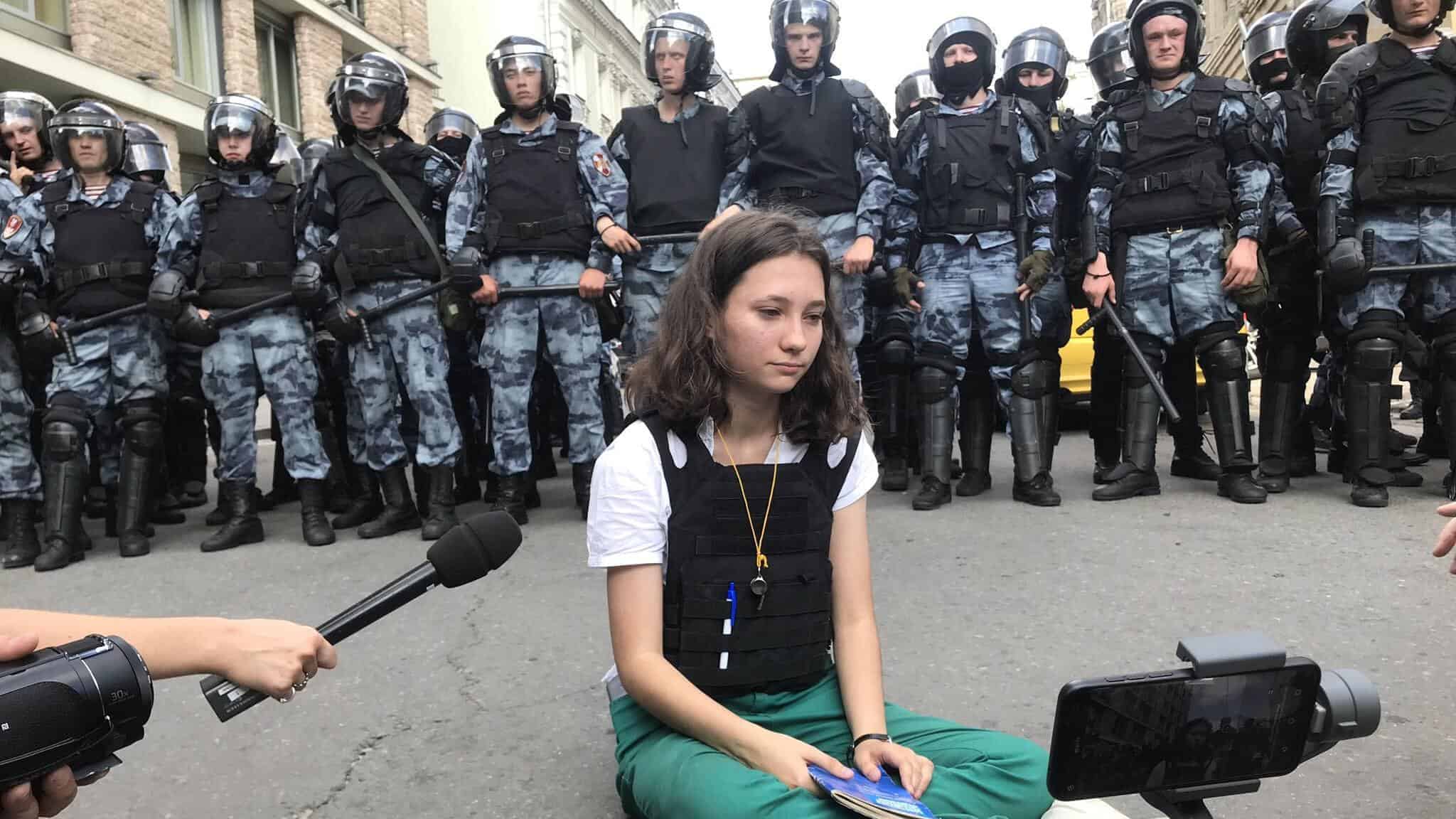 Viral photo shows teenage girl reading Russian constitution to riot police