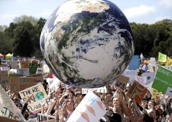 A large inflatable globe is bounced through the crowd as thousands of protesters join a climate change rally in Sydney (Rick Rycroft/AP)