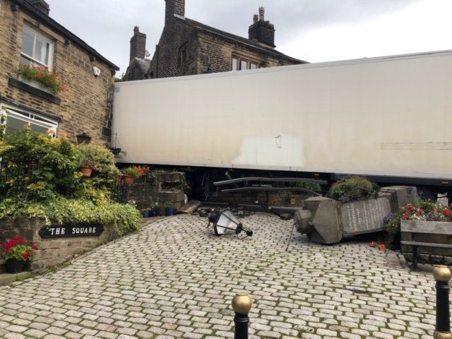 Photos show lorry which got stuck after crashing into a cottage in a picturesque village made famous by Richard Gere film Yanks