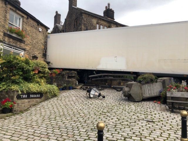 Photos show lorry which got stuck after crashing into a cottage in a picturesque village made famous by Richard Gere film Yanks