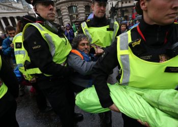 A protester is carried away by police as others block the road in front of the Bank of England (Gareth Fuller/PA)