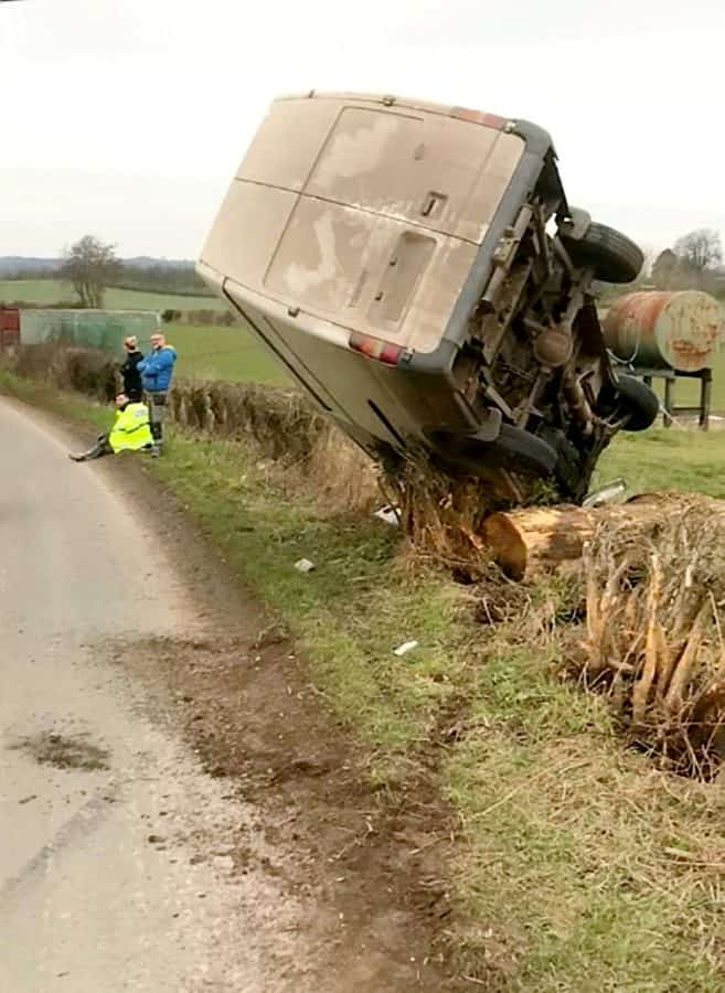 Driver saved after crashing van which was left perched precariously on a bush