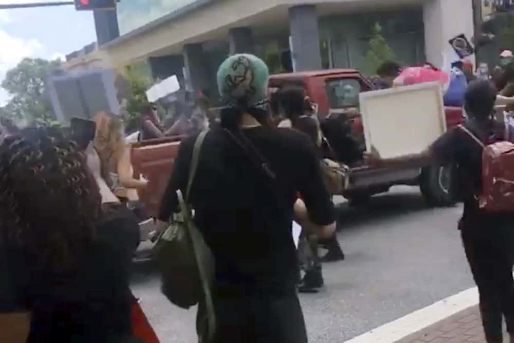 In this image taken from from video provided by @alexisnscott._, a pickup truck drives through a crowd of protesters, Saturday, May 30, 2020, in Tallahassee, Fla Tallahassee police said Saturday that the driver was in custody and that no one was seriously injured.  (@alexisnscott._ via AP)