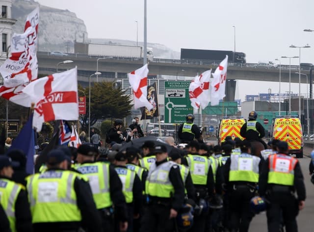Police officers march with far-right protesters though Dover in Kent as they demonstrate against the arrival of immigrants in 2016 Credit;PA