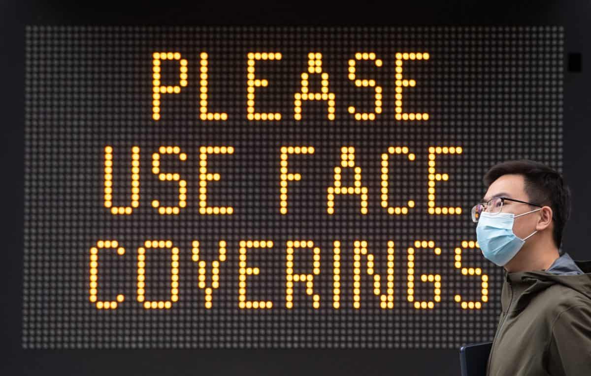 Embargoed to 0001 Thursday August 20 File photo dated 09/06/20 of a man wearing a protective face mask walking past signage advising the use of face coverings. Medical jargon surrounding masks may put some people off using face coverings, a new paper suggests.