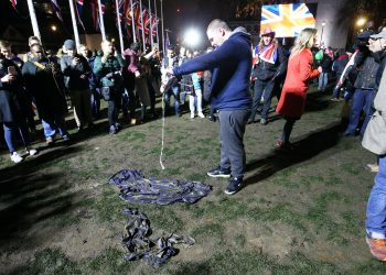 A pro-Brexit supporter pours beer onto an EU flag in Parliament Square (Jonathan Brady/PA)