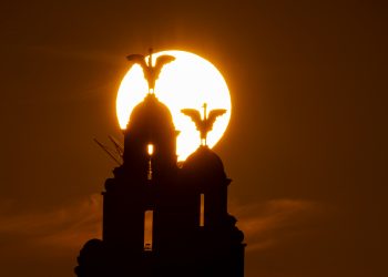 The sun rises behind the Royal Liver Building on Liverpool's waterfront, seen from across the river Mersey, ahead of the chance that Britain could bask in the hottest day of the year so far this week.