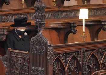 The Queen sitting alone whilst wearing a mask at her late husband Prince Philip's funeral. Photo: PA.