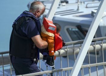 EDITORS NOTE Children's faces have been pixelated as the PA Picture Desk has been unable to gain the necessary permission to photograph a child under 16 on issues involving their welfare. A young child is carried ashore as a group of people thought to be migrants are brought in to Dover, Kent, by Border Force officers, following a small boat incident in the Channel. Picture date: Sunday August 15, 2021.