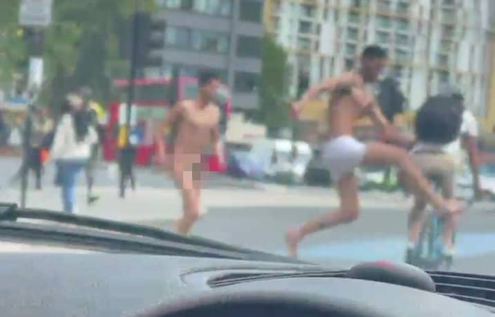 Watch: Naked man strolled down London street – before his semi-clothed pal knocked a cyclist off bike