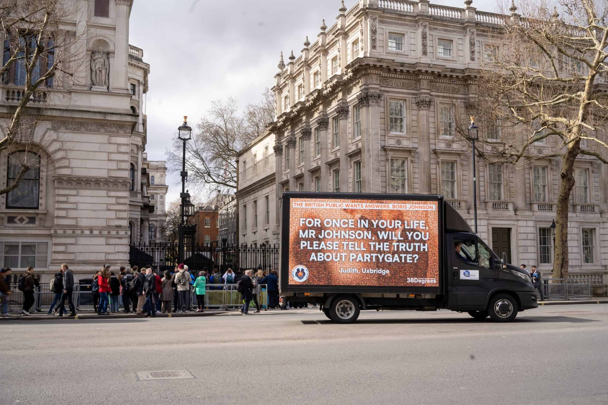 Ad van displaying messages from Covid bereaved driven around Westminster during Johnson inquiry